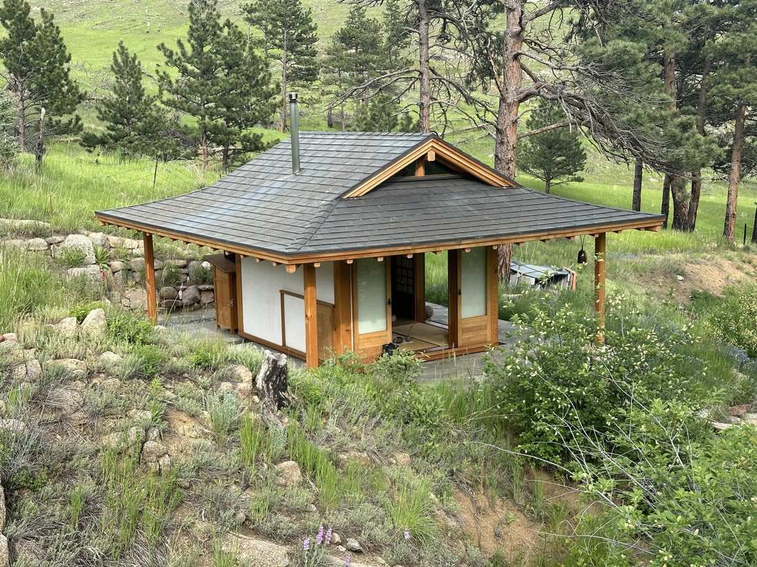 The teahouse in full summer green, mountains beyond