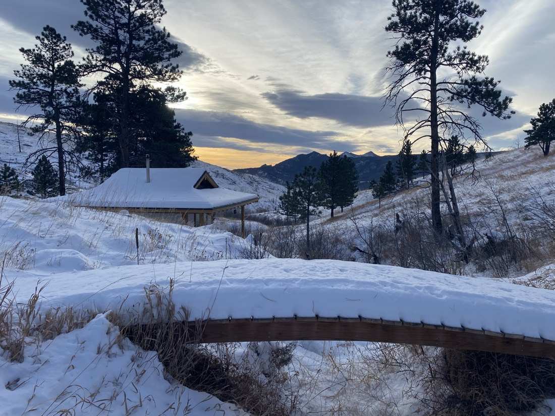 The teahouse and footbridge under deep snow at sunset