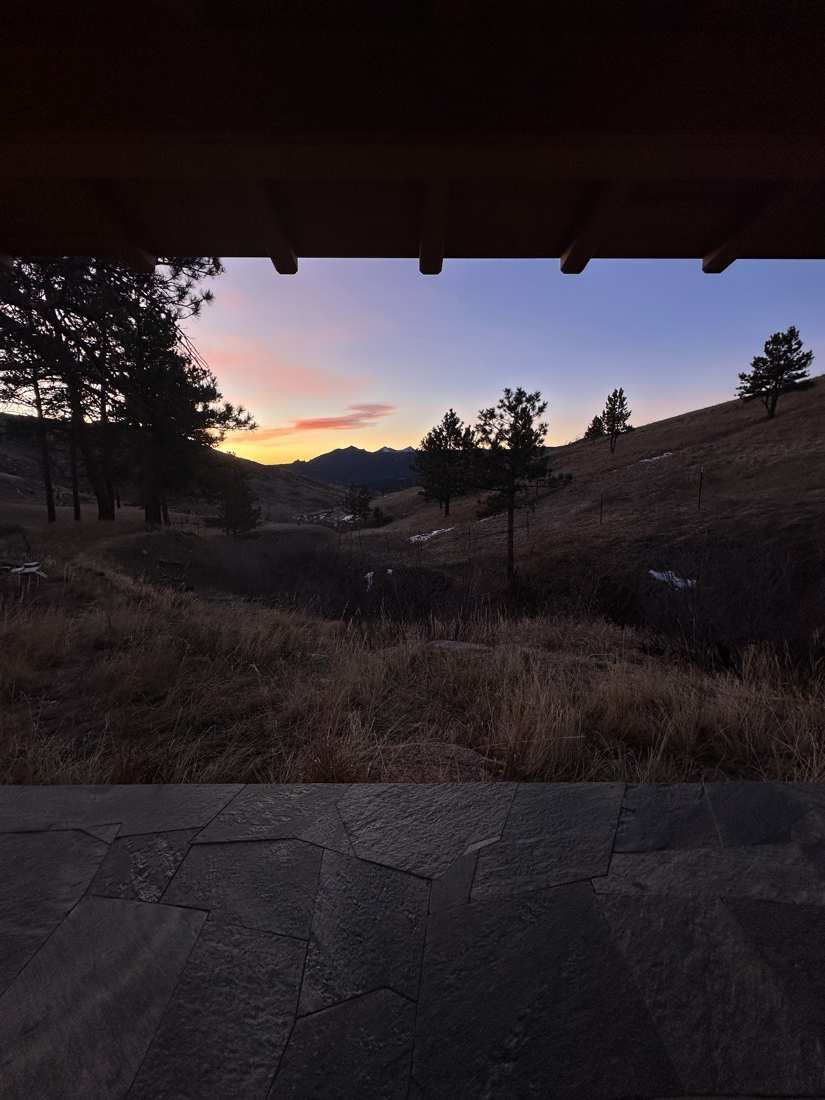 Winter sunset over the valley, framed by the teahouse eave and stone patio