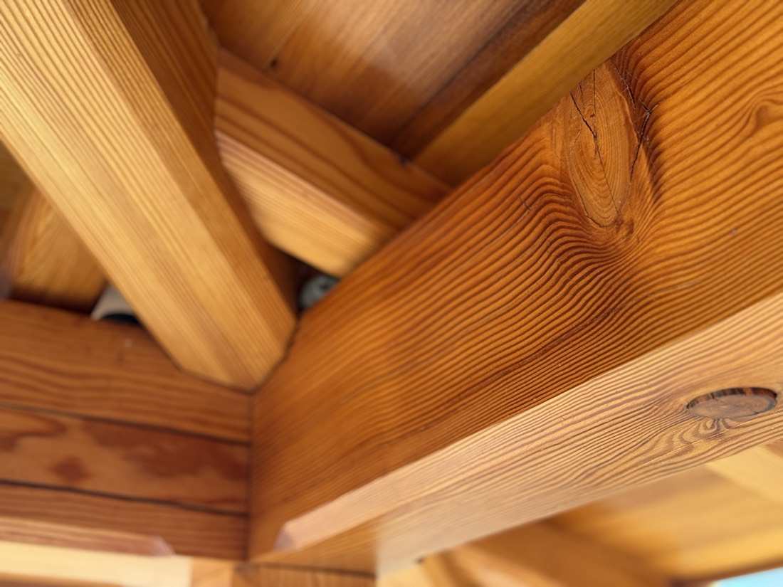 Close-up of warm fir joinery, grain curling like water