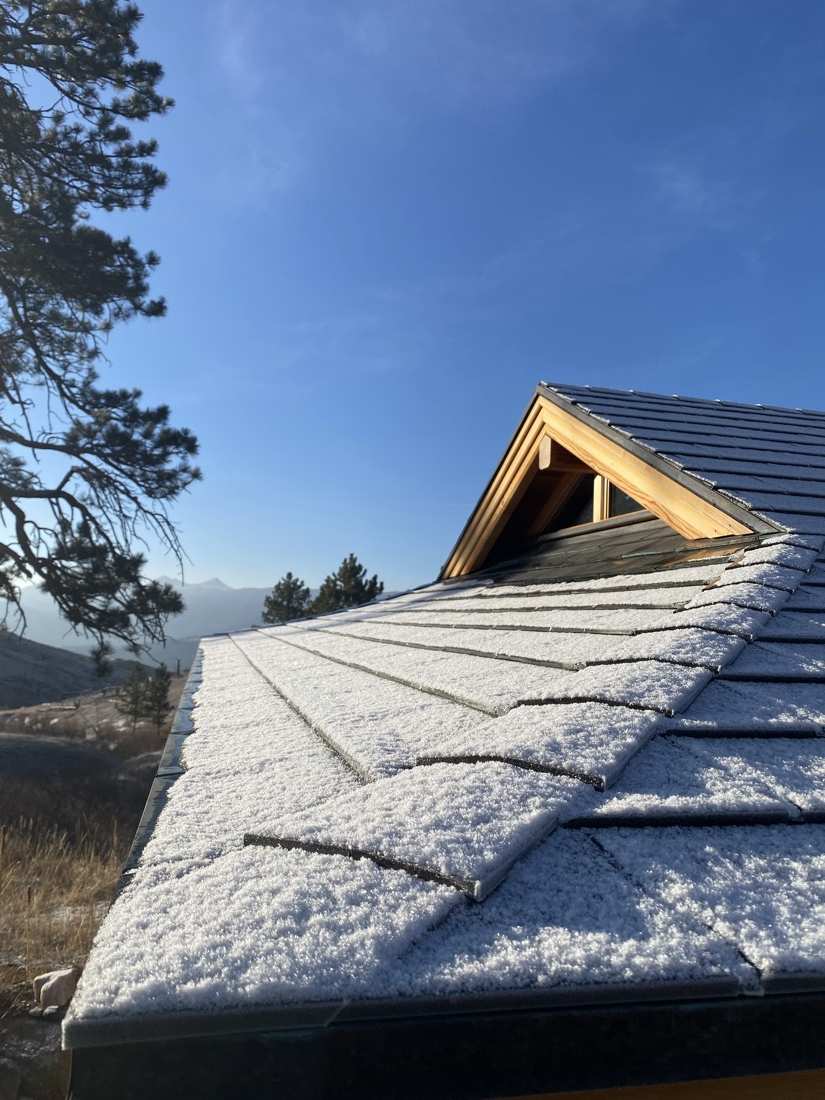 Fresh snow on the teahouse roof and gable joinery under deep blue sky